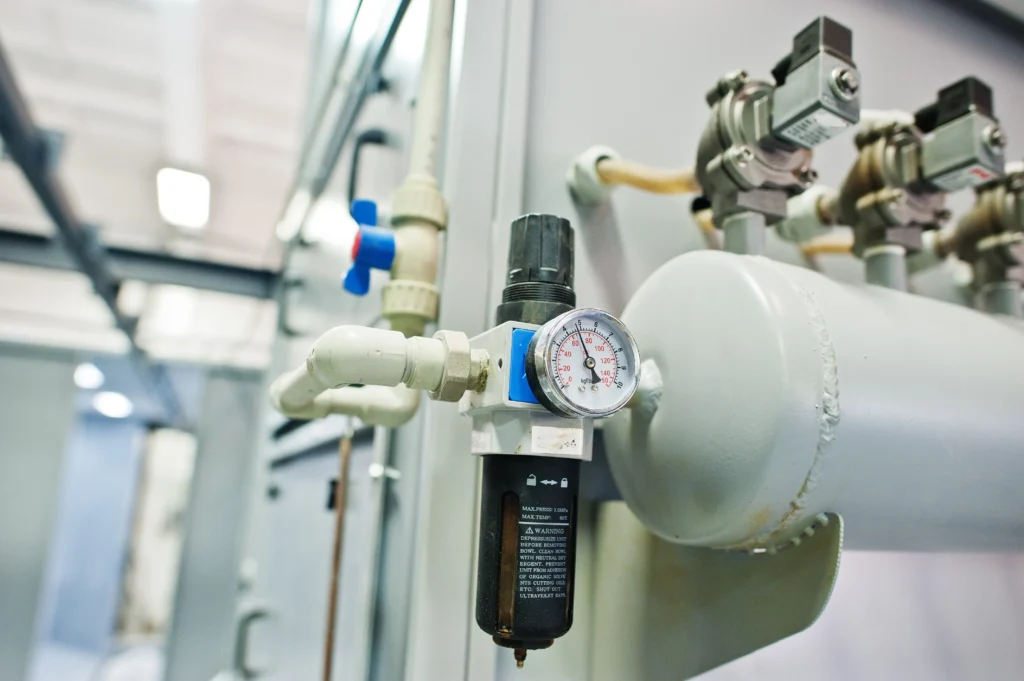An industrial pressure gauge connected to a network of pipes