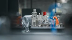 Close up of factory equipment including pneumatic fittings and tubes.