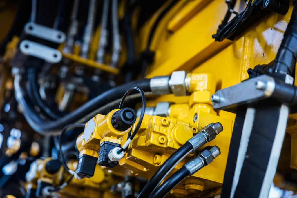 Close up of yellow industrial machine components with hydraulic system