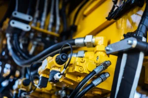 Close up of yellow industrial machine components with hydraulic system